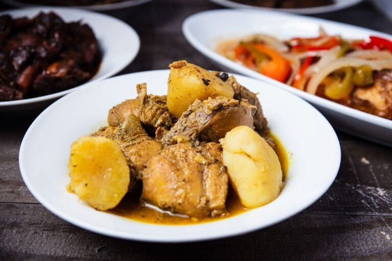 Jamaican Brown Stew Chicken with Coconut Dumplings, Callaloo, and Fried Plantains
