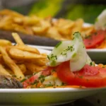 Pan-fried fish with fries and tomato salad