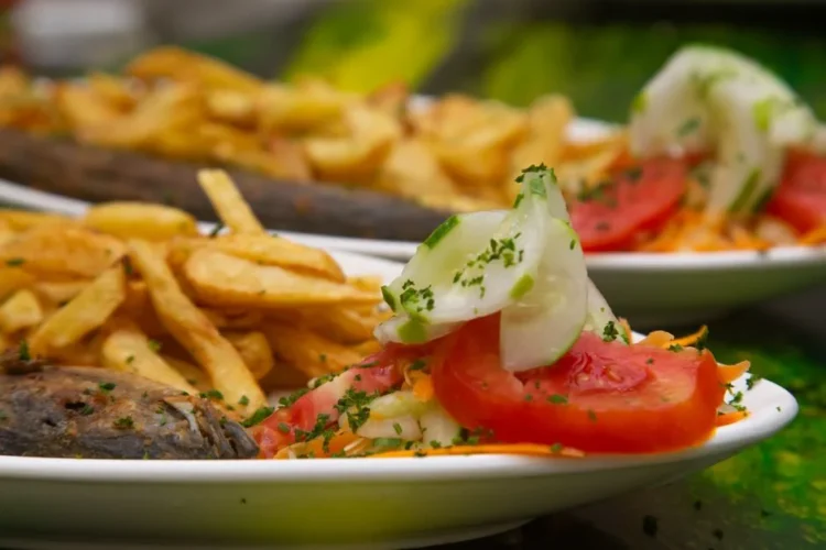 Pan-fried fish with fries and tomato salad