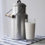 Glass of milk drink with metal jug
